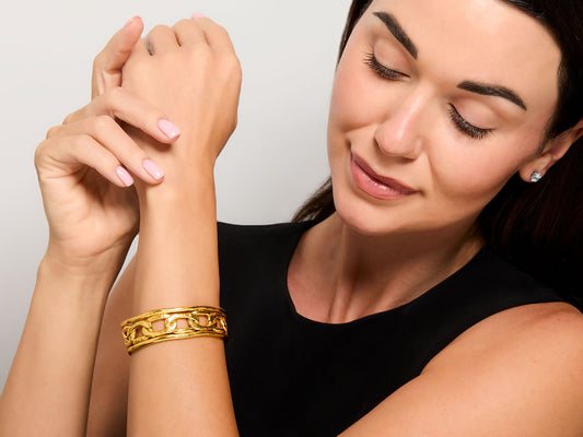 Woman wearing a sculpted 22K gold openwork cuff bracelet