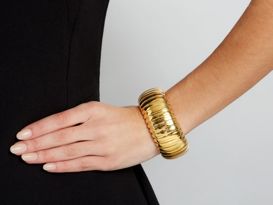 Wide domed 18K gold tubogas cuff bracelet on wrist