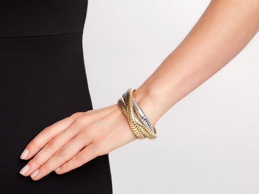 Three interlocking 18K gold tubogas bracelets on wrist