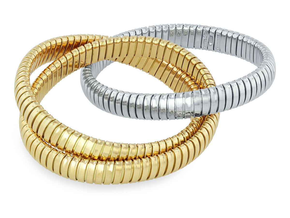Three interlocking tubogas bracelets in yellow and white gold