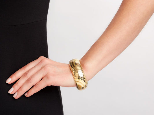 Domed 18K yellow gold cuff bracelet on wrist