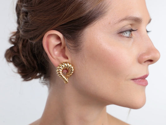 Woman wearing a twisted 18K gold hoop earring