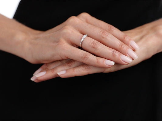 Hand wearing a platinum ring with three baguette diamonds