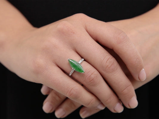 Hand wearing a navette green jade and diamond ring
