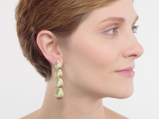 Woman wearing 18K gold diamond teardrop earrings