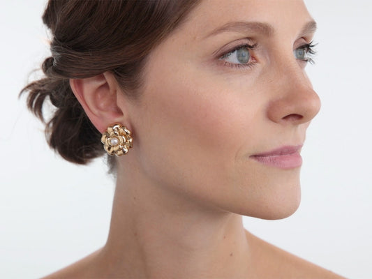 Woman wearing a gold floral pearl earring