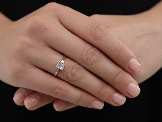 Hand wearing a square Art Deco diamond ring