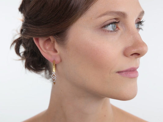 Woman wearing a textured gold double heart hoop earring