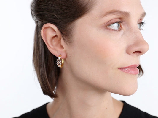 Woman wearing a small gold double-heart hoop earring