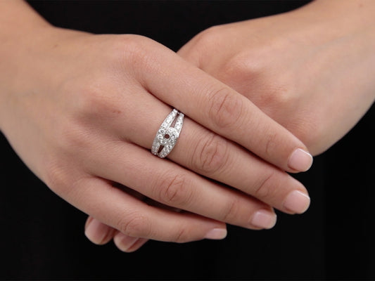 Hands wearing an 18K white gold ring with diamond loops