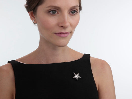 Woman wearing a silver star brooch on a black dress