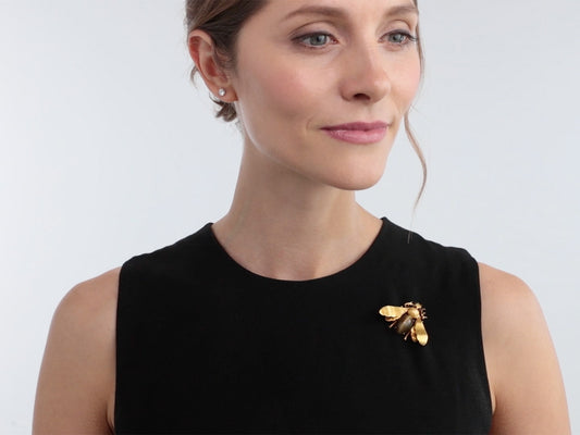 Woman wearing a realistic gold fly brooch