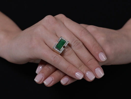 Hand wearing a rectangular jade and diamond ring