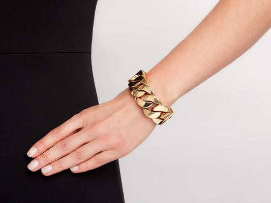 Polished 18k gold curb link bracelet worn on wrist