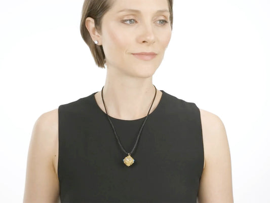 Woman wearing a spherical gold pendant on a black cord