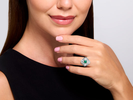 Woman wearing an emerald and diamond platinum ring