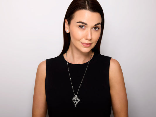 Woman wearing an ornate diamond and pearl pendant necklace
