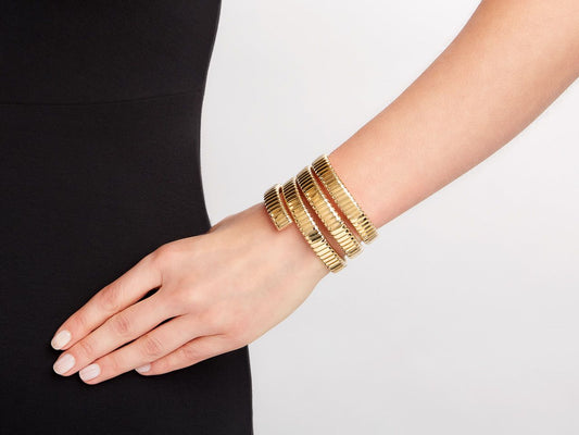 Three coil 18K gold bracelet worn on wrist