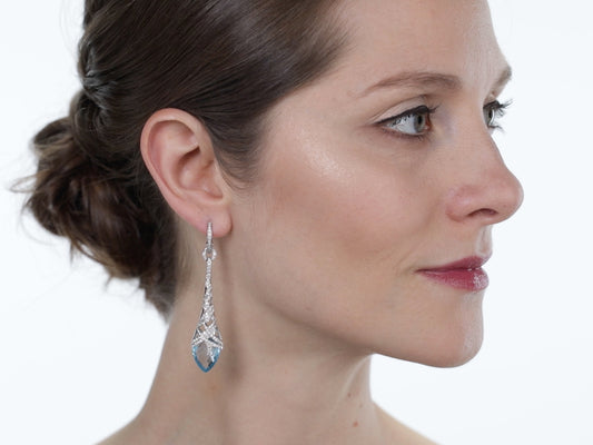 Woman wearing a blue topaz and diamond drop earring