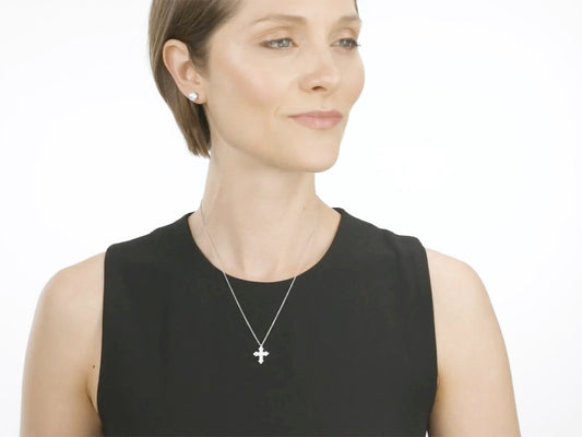 Woman wearing a small diamond cross pendant