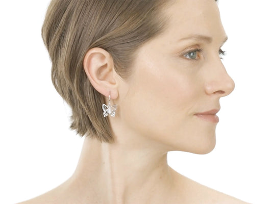 Woman wearing diamond butterfly earrings in white gold