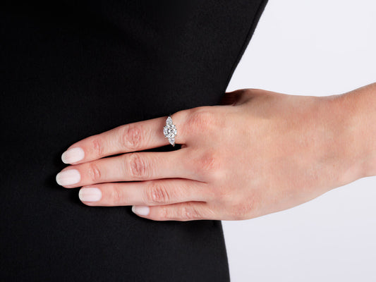 Hand wearing a diamond ring with pear shaped side stones