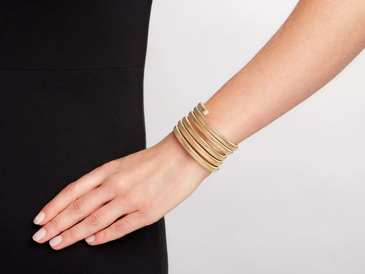Five row gold wrap bracelet worn on a wrist