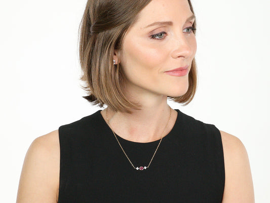 Woman wearing a ruby and diamond gold necklace