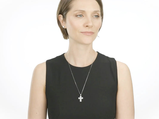 Woman wearing a diamond cross pendant in white gold