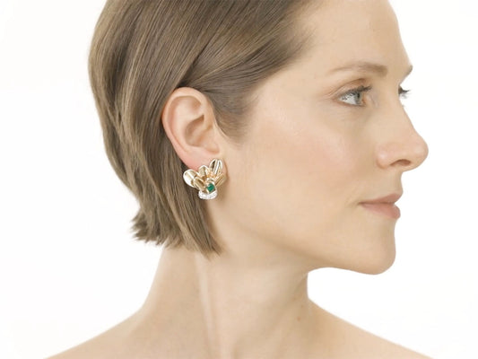 Woman wearing a fan shaped emerald and diamond gold earclip