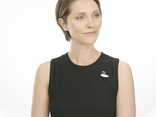 Woman wearing a pearl and diamond swan brooch