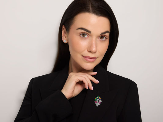 Woman wearing a colorful floral brooch on a black blazer