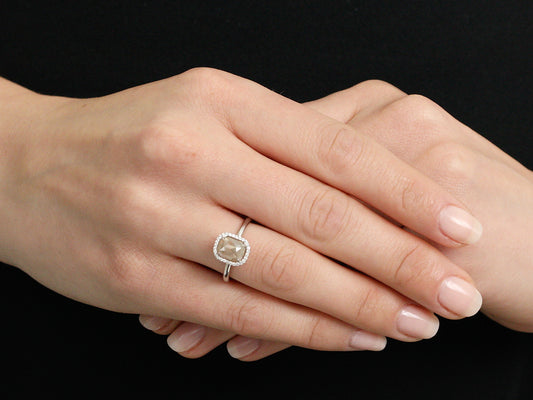 White gold halo ring with raw diamond worn on hand