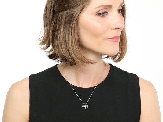 Woman wearing a white gold dragonfly pendant necklace