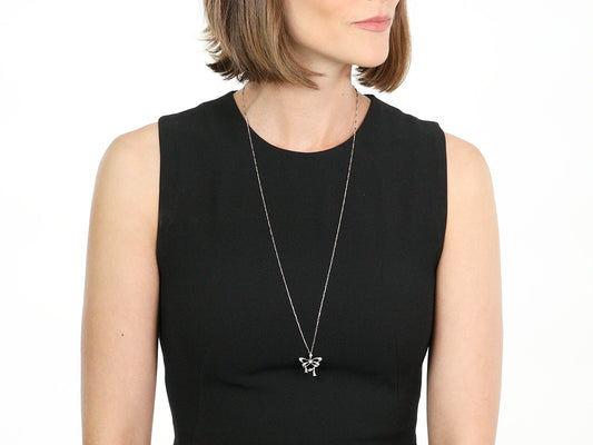Woman wearing a platinum diamond bow pendant necklace