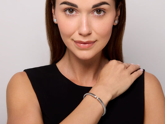 Woman modeling a thin 18K white gold tubogas diamond bracelet