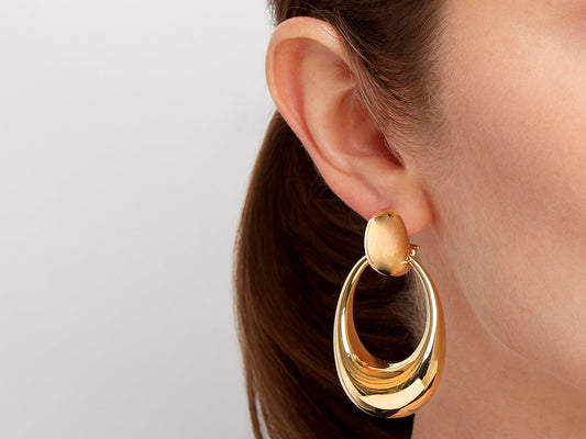 18K gold door knocker earring worn on an ear