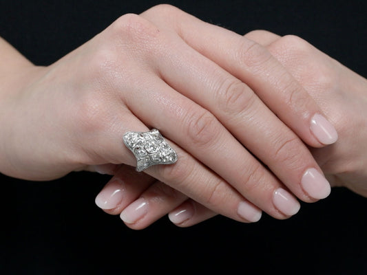Platinum filigree diamond ring worn on hand