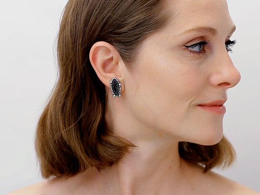 Woman wearing a black geode and diamond stud earring