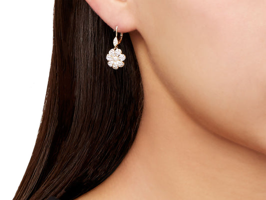 Diamond flower earring in 18K gold worn on ear