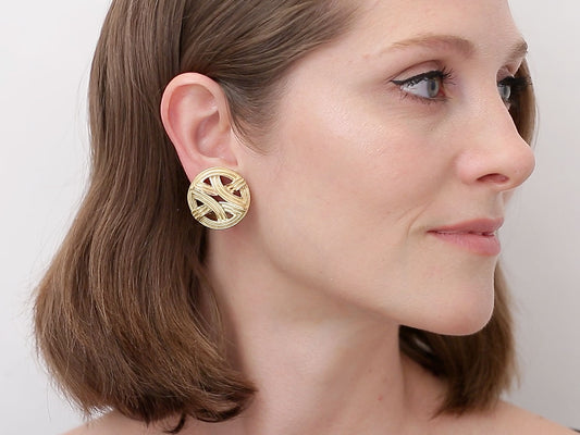 Woman wearing open disc earrings in yellow and rose gold