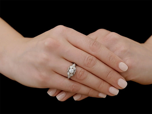 Art Deco platinum diamond ring worn on clasped hands