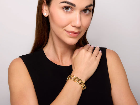 Woman wearing a polished 18K gold curb link bracelet