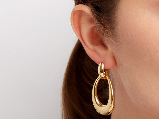 18K gold door knocker earring worn on an ear