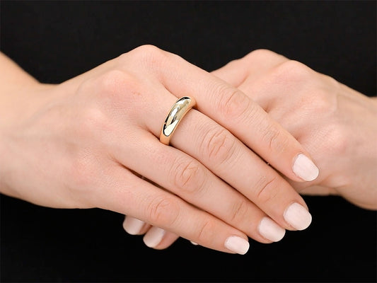 Polished gold bombe ring worn on a hand