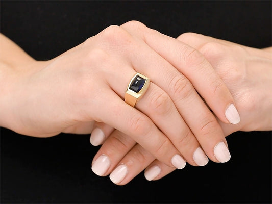 Hand wearing an angular gold sapphire ring