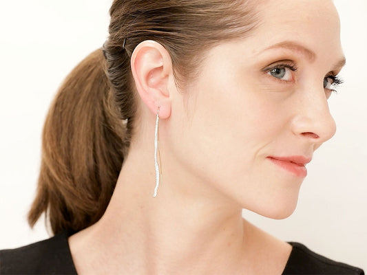 Woman wearing a gold diamond snake dangle earring
