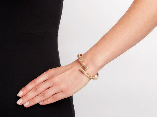 Rose gold tubogas bypass bracelet with diamond nail head terminals on wrist