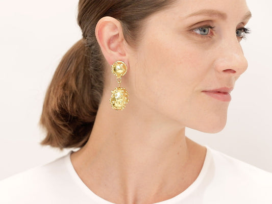 Woman wearing hand hammered 22K gold oval drop earrings