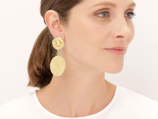 Woman wearing a hammered 22K gold disc drop earring